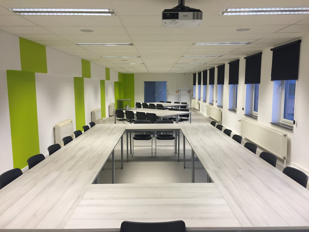service-06 Spacious indoor meeting room with modern furniture and large windows.