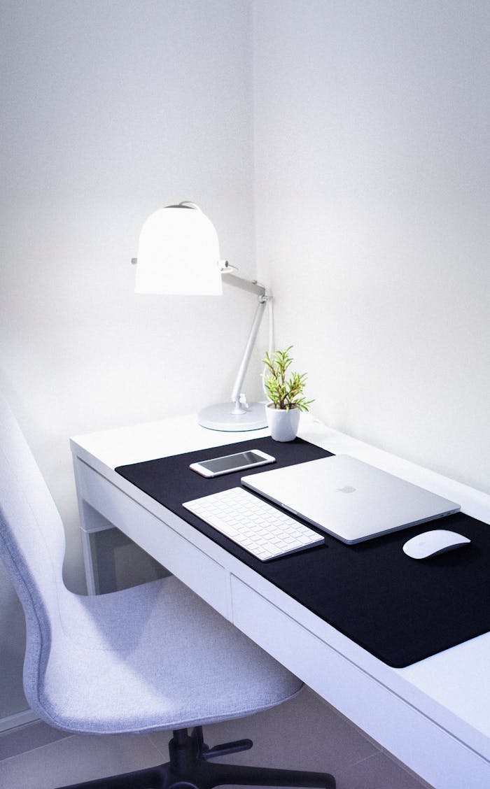 service-05 Sleek, modern home office setup featuring Apple devices, a desk lamp, and a plant.